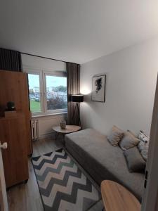 a bedroom with a bed and a table and a window at Piotrków Trybunalski Comfort Apartment by BookingHost in Piotrków Trybunalski