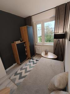 a small living room with a table and a window at Piotrków Trybunalski Comfort Apartment by BookingHost in Piotrków Trybunalski +16 photos
