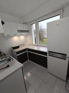 a kitchen with a white refrigerator and a window at Piotrków Trybunalski Comfort Apartment by BookingHost in Piotrków Trybunalski