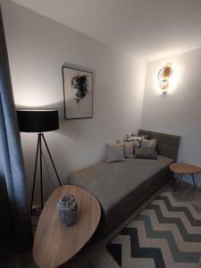 a small bedroom with a bed and a table at Piotrków Trybunalski Comfort Apartment by BookingHost in Piotrków Trybunalski