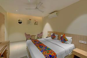 a bedroom with a bed and a table and chairs at FabHotel Blue Moon in Hanamkonda