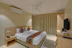 a hotel room with a bed and a television at FabHotel Blue Moon in Hanamkonda