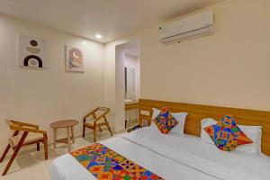 a bedroom with a bed and a table and chairs at FabHotel Blue Moon in Hanamkonda +21 photos