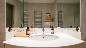 a bathroom with a sink and a mirror at Le Prieuré d'Arbois in Arbois +28 photos