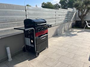 a grill sitting on a patio next to a fence at I Siciliani beach house in Mascali