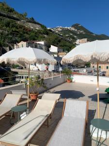 a patio with tables and chairs and umbrellas at Casa Margherita in Minori