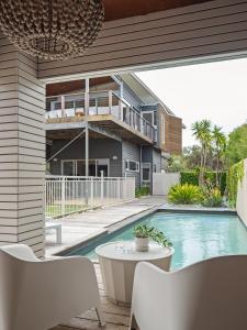 a house with a swimming pool with a table and chairs at Seabreeze Escape, Coastal Stay in Gnarabup