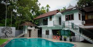 une villa avec piscine devant une maison dans l'établissement Mangrove Heritage Home, Chendamangalam, à Cochin