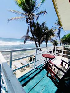 a balcony with a table and chairs and the beach at Why Not Guest house in Hikkaduwa