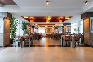 a dining room with tables and chairs in a restaurant at Pensiunea All Seasons in Iaşi