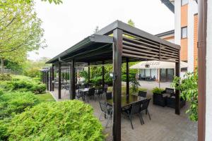 a patio with tables and chairs under a canopy at Pensiunea All Seasons in Iaşi