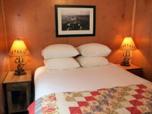 Un dormitorio con una cama blanca con dos lámparas. en Secluded Cabin Perfect for a Romantic Getaway in Austin County, Texas, en Cat Spring