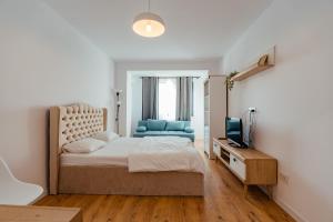 une chambre avec un lit et une télévision dans l'établissement Ivory by Blvd 25B4 - Premium Studio with Garden View, à Bucarest