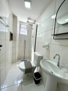een witte badkamer met een toilet en een wastafel bij Studio 107 in Sao Paulo