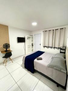 een slaapkamer met een bed en een televisie. bij Studio 107 in Sao Paulo