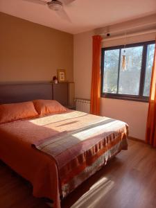 een slaapkamer met een bed en een groot raam bij CuyenCo Casa de campo in Santa Rosa de Calamuchita