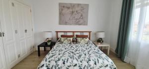 a bedroom with a bed and two tables with lamps at puerto de la cruz playa jardin in Puerto de la Cruz +4 photos