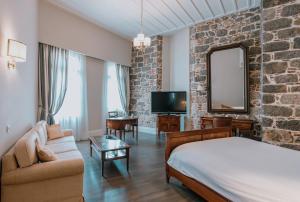 una camera con letto, divano e specchio di Xenon Inn a Nauplia