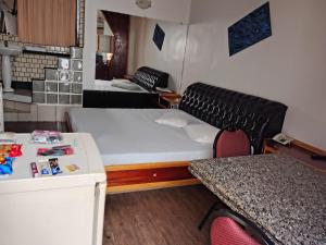 a room with a bed and a table and a couch at motel millenium in Betim