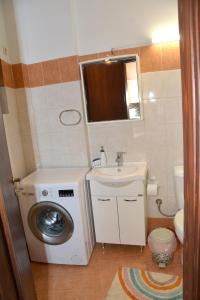 a bathroom with a washing machine and a sink at Αρσινόη apartments 4 in Arachova