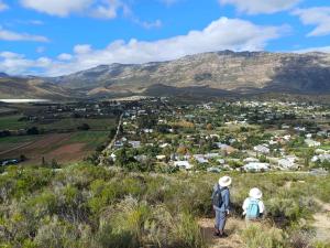 two people standing on a hill looking at a city at Birdsong Barrydale in Barrydale