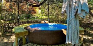Un jacuzzi situado en una terraza de madera en Secluded Cabin Perfect for a Romantic Getaway in Austin County, Texas, en Cat Spring