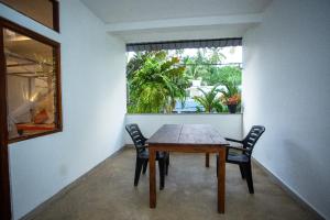 Una mesa y sillas en una habitación con ventana. en Mealanie's House, en Unawatuna
