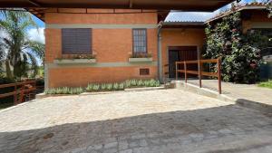 a house with a brick driveway in front of it at Café e Pousada Jardim Secreto in Santa Rita do Sapucaí