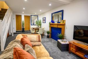 a living room with a couch and a tv at James Terrace by STAE Homes in Porth