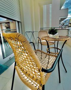 una silla de mimbre y una mesa en el balcón en Aqua Marine B&B - Rooms and Apartments, en Milazzo