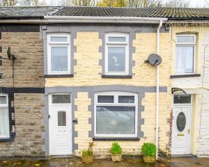 a brick house with white doors and windows at James Terrace by STAE Homes in Porth