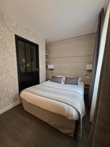 a bedroom with a large bed in a room at Logis Hôtel Restaurant Le Quai Fleuri in Voves