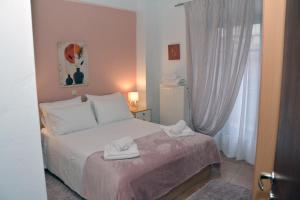 a bedroom with a bed with two white towels on it at Αρσινόη apartments 4 in Arachova