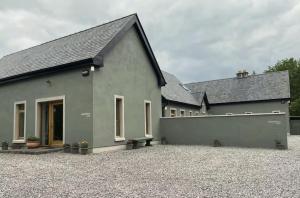 a large gray house with a large garage at Woodview Studio - Westport in Westport