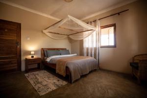 ein Schlafzimmer mit einem Bett und einem Fenster in der Unterkunft Rain Tree Camp in Chunga