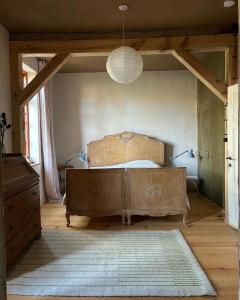 a bedroom with a large bed with a wooden headboard at Entschleunigen im Fachwerkhaus am Wald in Vielank +28 photos