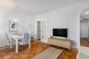a living room with a table and a tv at Playa Grande by H- Playa Punta del Moral PPHG136P111 in Isla del Moral
