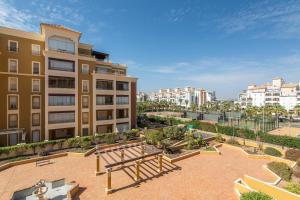 an apartment building with a park in front of it at Playa Grande by H- Playa Punta del Moral PPHG136P111 in Isla del Moral