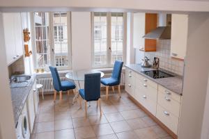 een keuken met blauwe stoelen en een tafel. bij La Belle Époque Apartment in Luxemburg +18 foto's
