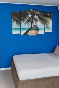 a bedroom with a blue wall with a bed and a beach at Signature Promenada Beach in Mamaia Nord