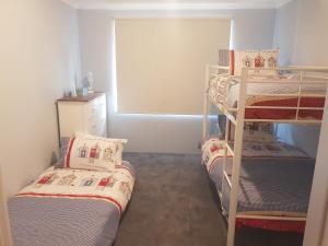 a room with two bunk beds and a window at Sandy Toes and Sunsets Beach House in Bunbury
