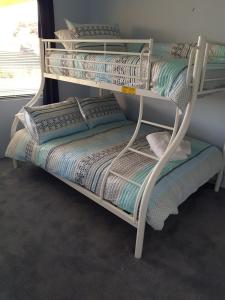 a stack of bunk beds in a room at Sandy Toes and Sunsets Beach House in Bunbury