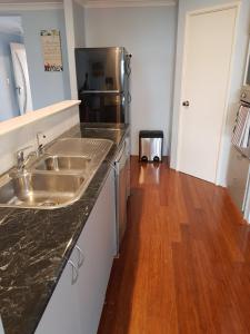 a kitchen with a sink and a wooden floor at Sandy Toes and Sunsets Beach House in Bunbury +27 photos