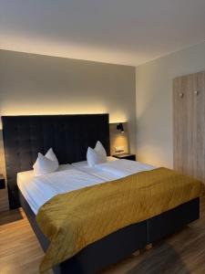 a bedroom with a large bed with white sheets at Vinotel Dirmstein in Behringen