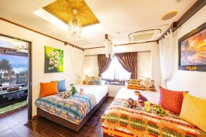 a bedroom with two beds and a couch at Hotel Balian Resort Tomei Kawasaki I.C. in Kawasaki