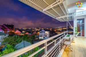 un balcon avec vue sur une ville la nuit dans l'établissement Villa Tuan Vu Da Lat - Retreat, à Đà Lạt