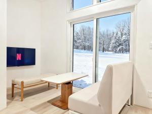a living room with a table and a window at Lagom Hakuba in Hakuba