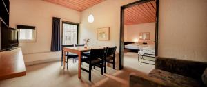 a room with a table and chairs and a bedroom at Kysthotellet in Grenå