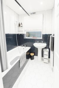 ein weißes Badezimmer mit Badewanne und Waschbecken in der Unterkunft Double Room close to EFC LFC Liverpool City Centre in Liverpool