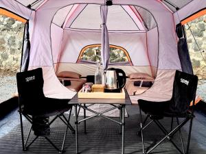 a table and two chairs in a tent at KAIA Camp by Kalimaya in Cicadas